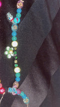 Colorful beaded earrings on a dark fabric background