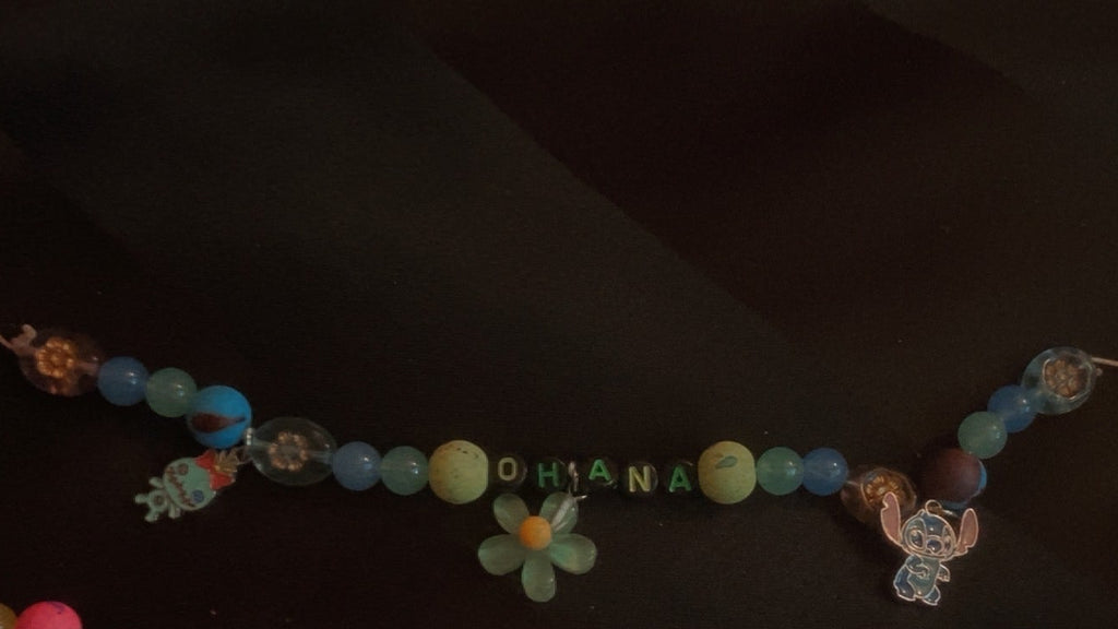Colorful beaded necklace with floral decorations on a dark background