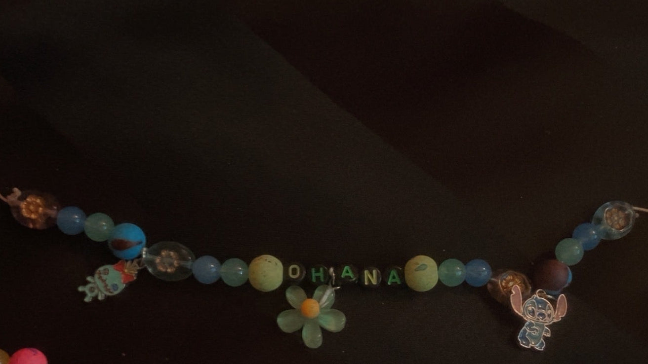 Colorful beaded necklace with floral decorations on a dark background